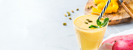 Healthy organic mango lassi, smoothie, shake, indian drink beverage with yogurt and fresh ripe fruits on a kitchen table. Copy space background